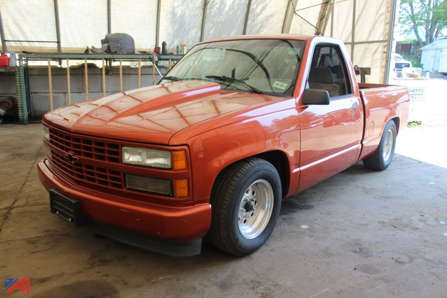 Front three-quarter view of a red 1992 Chevrolet C/K 1500 pickup truck in a covered area.