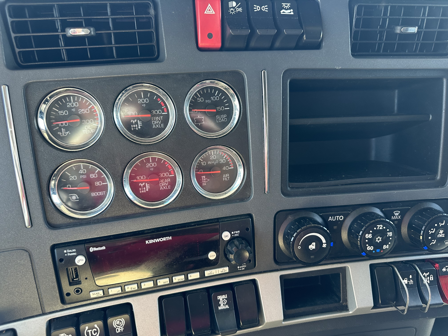 Kenworth T680 dashboard and instrument cluster with multiple gauges and Kenworth radio visible in center.
