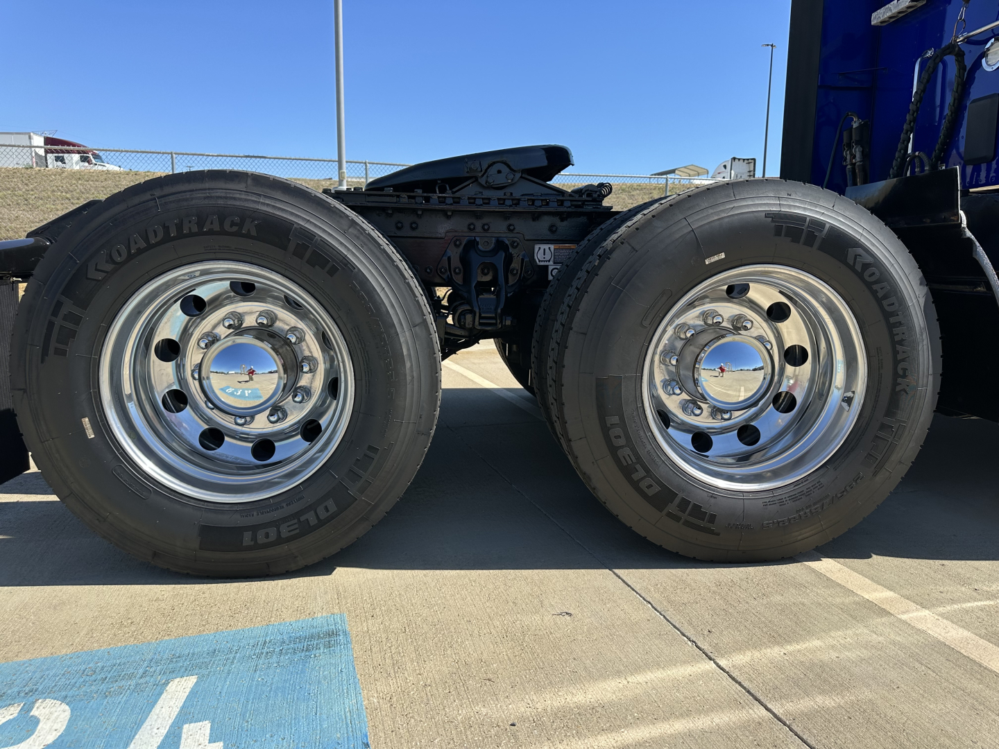 Kenworth T680 truck chassis with dual rear axles and chrome wheels, view of suspension and tires.