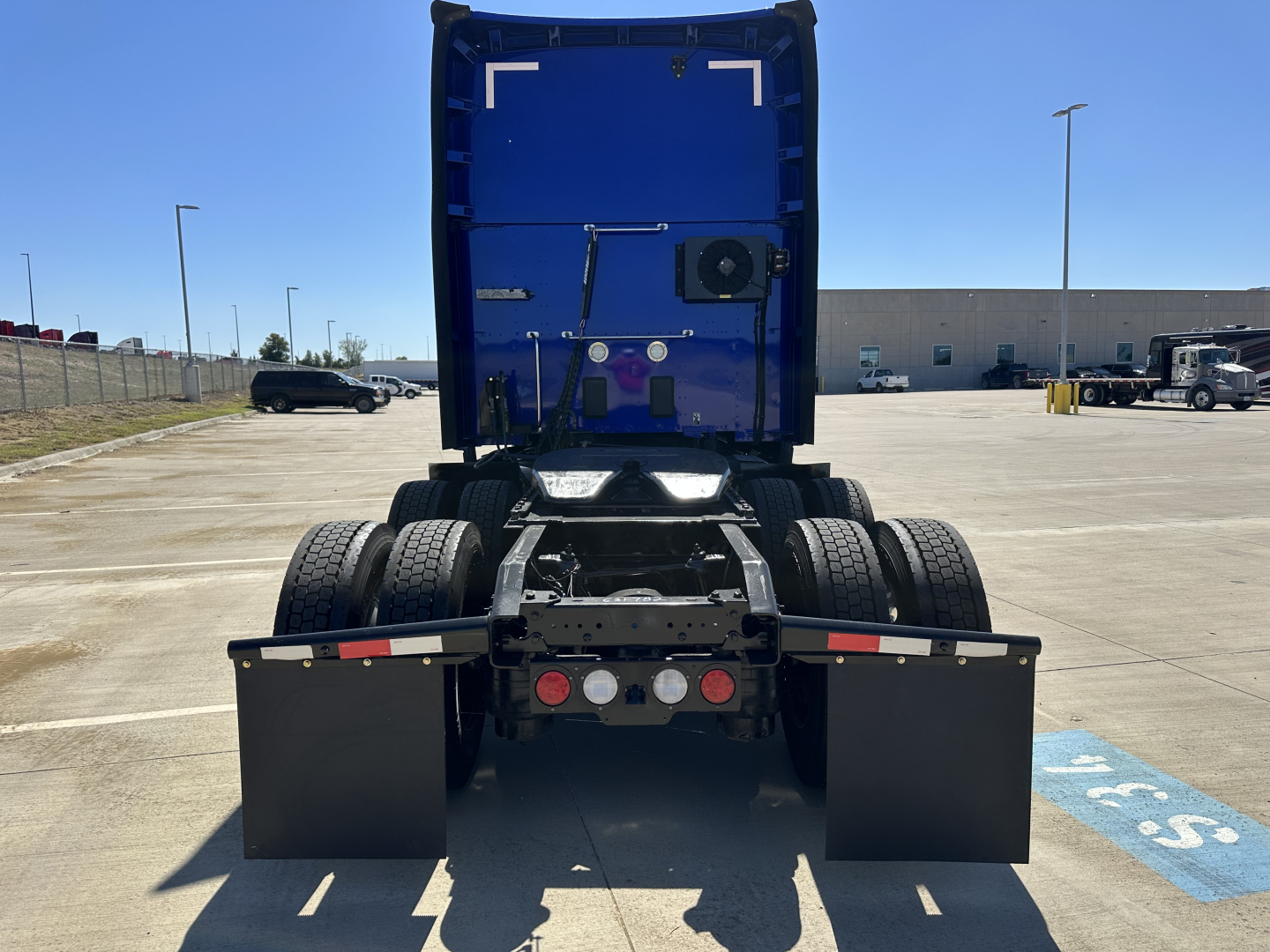 Kenworth T680 rear view showing fifth wheel and dual rear axles with mud flaps and LED lights.