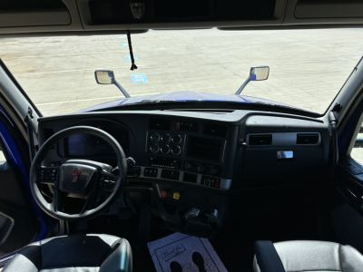 Cab interior of 2023 Kenworth T680 with steering wheel, dashboard, gauges, and center console visible.