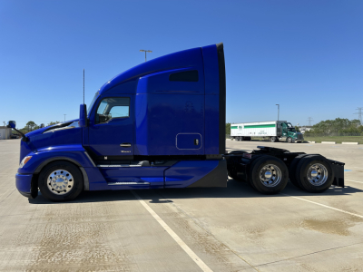 Kenworth T680 sleeper tractor in blue side profile showing cab and rear wheels with tag identifiers not legible.