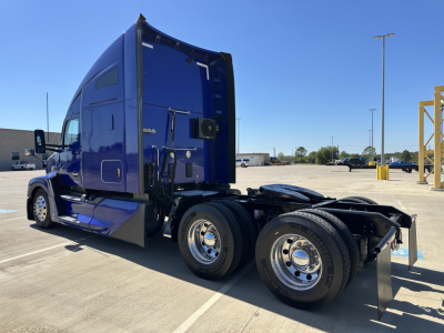Kenworth T680 tractor-trailer cab side view showing blue exterior and rear wheels