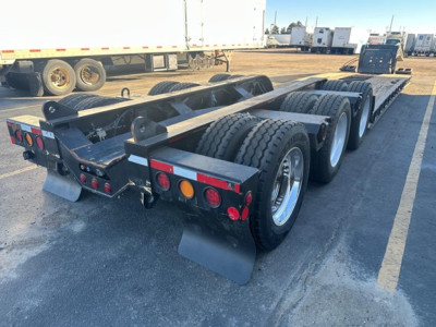 Trailer rear view of a Fontaine 55 Lcc lowboy with triple axle group, dual rear mud flaps, tail lights, and spare wheels. Visible tires and wheel wells.