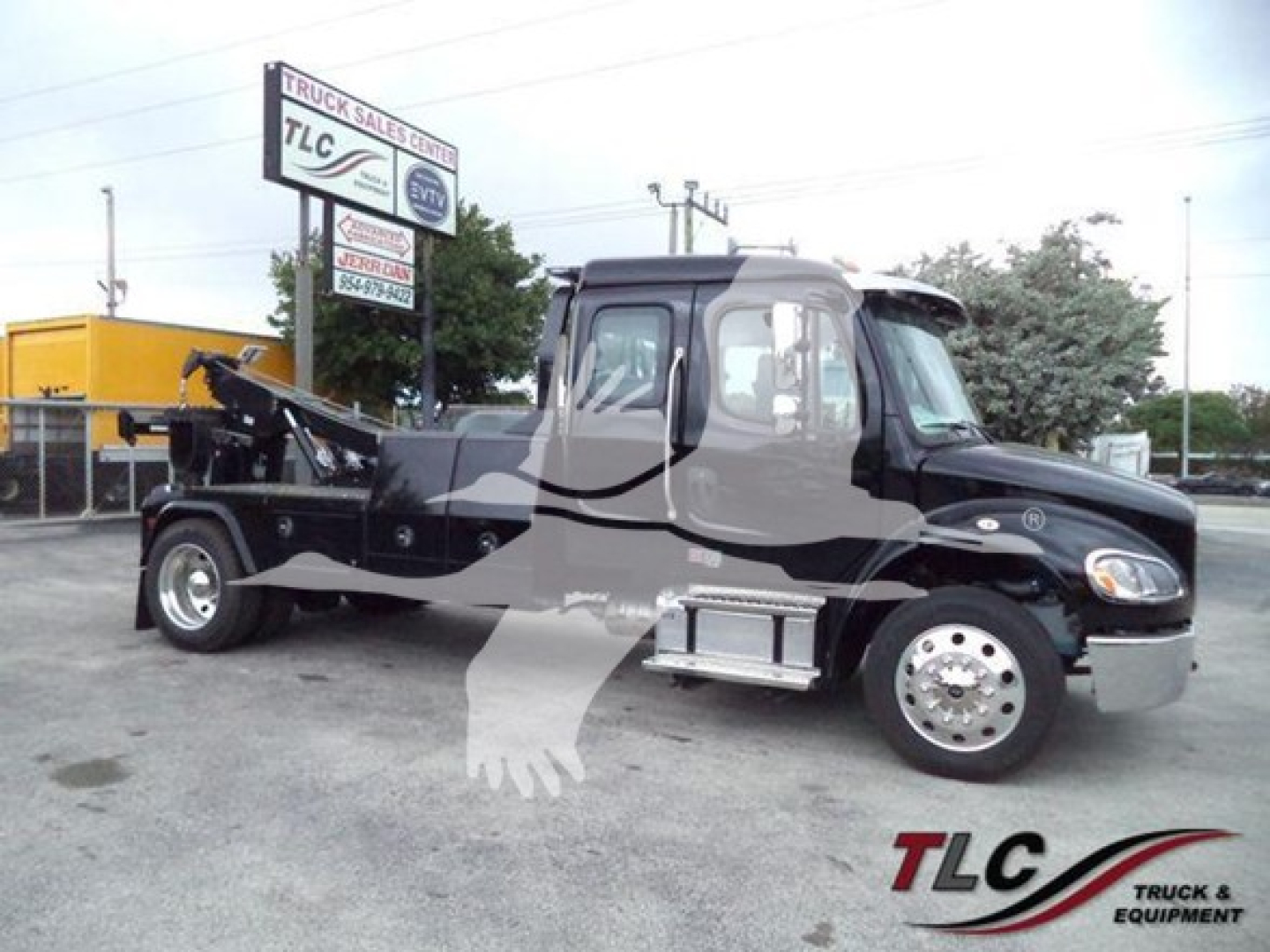 Freightliner M2 106 tow truck side view showing winch and crane apparatus, cab with chrome steps and dual rear wheels.
