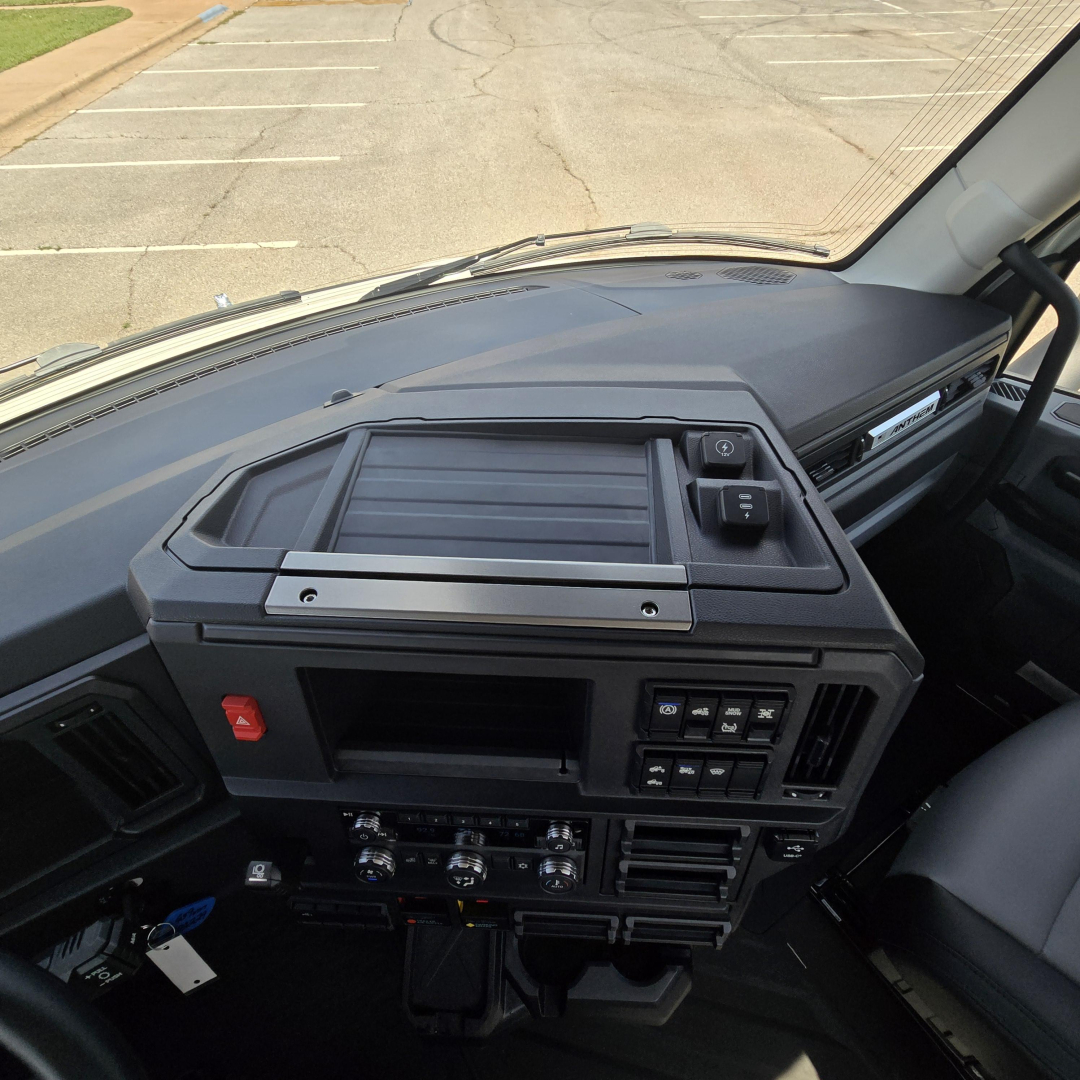 Dashboard cockpit of a new 2027 Mack AN64T daycab showing controls, vents, and center console.