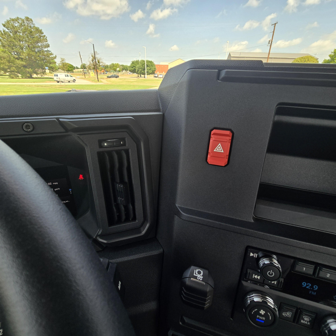 Dashboard area of a 2027 Mack AN64T truck showing instrument panel, hazard button, air vent, and radio controls.