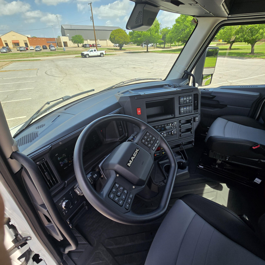 Mack AN64T truck interior showing steering wheel, dashboard, and driver seat from open cab, with controls and vents visible.