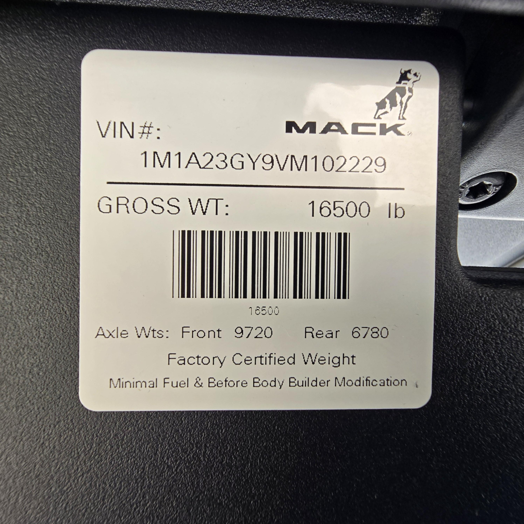 Mack plate and VIN sticker on truck showing VIN 1M1A23GY9VM102229, GROSS WT 16500 lb, Axle Wts Front 9720 Rear 6780, barcode, 'Factory Certified Weight', minimal fuel & before body builder modification