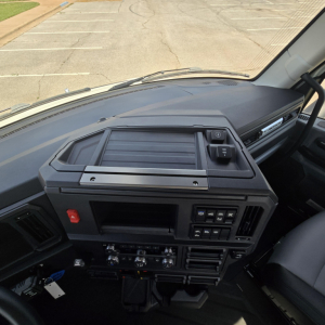 Dashboard cockpit of a new 2027 Mack AN64T daycab showing controls, vents, and center console.