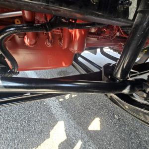 Mack AN64T engine bay showing red oil pan and black chassis components under the cab.