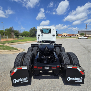 Truck chassis and rear view of a 2027 Mack AN64T conventional daycab showing dual rear axles, dual tires, mud flaps with Bruckner's Truck & Equipment logos, and fifth-wheel area.