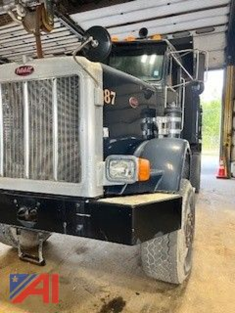 Peterbilt 357 dump truck front view showing grille, bumper, headlights and large front tire.