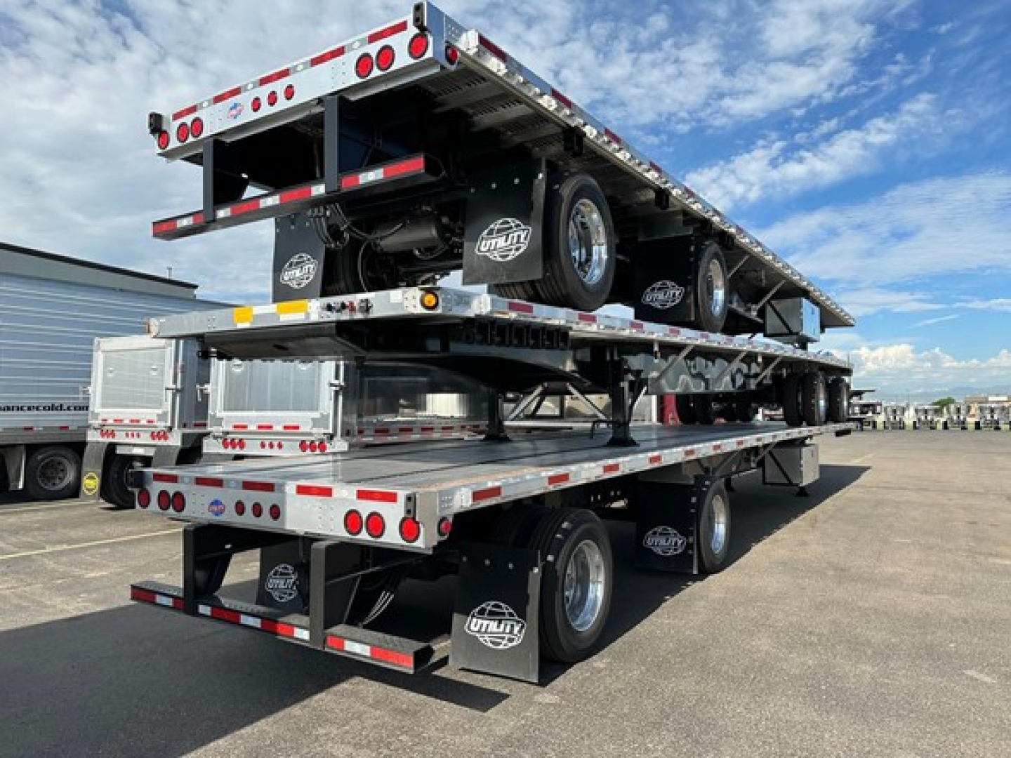 Utility 4000Ae flatbed trailer stacked with dual rear and upper deck, showing flatbed platforms, wheels, and Utility brand mud flaps.