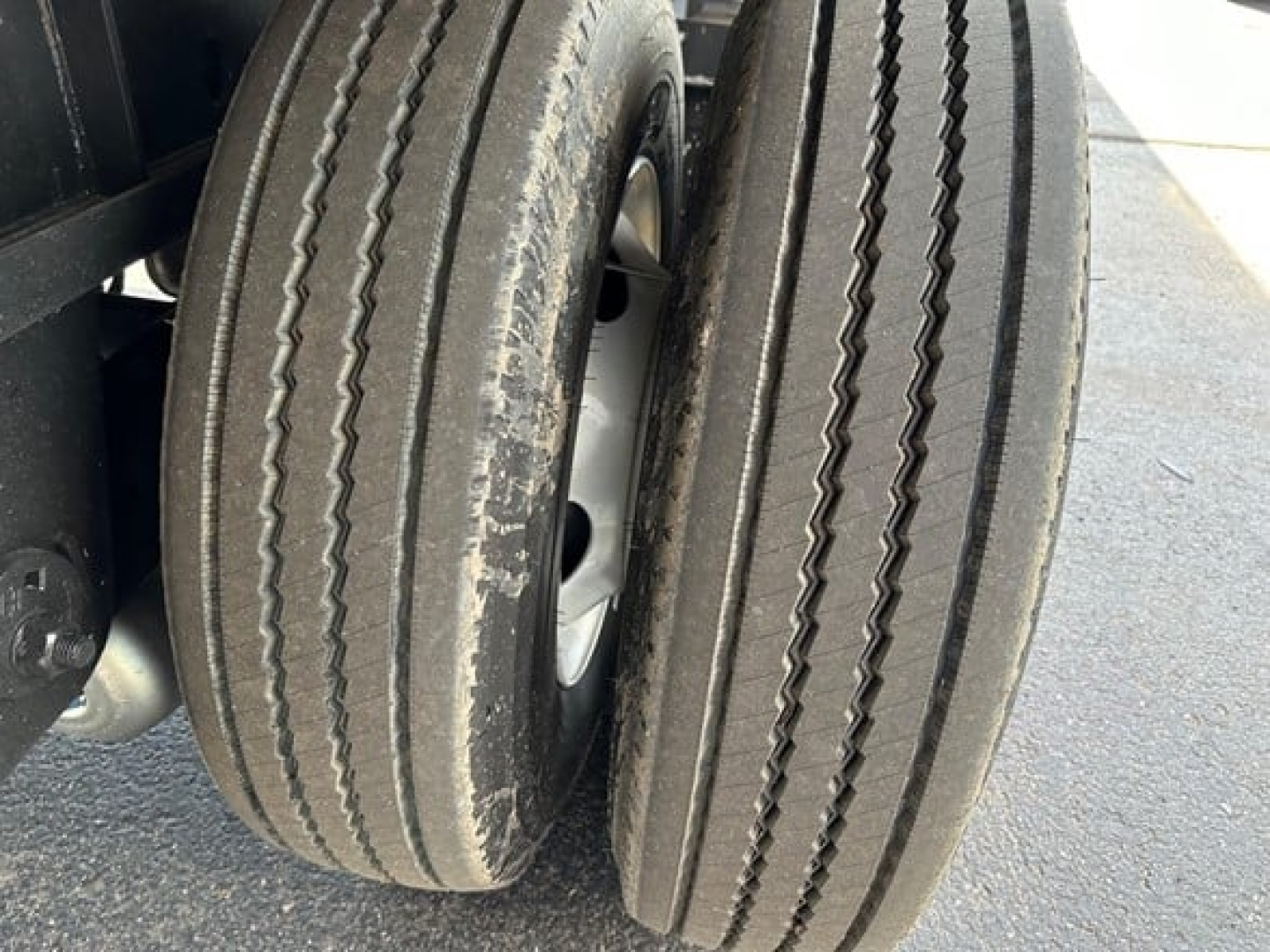 Dual rear trailer tires with tread patterns visible on the outer rims.