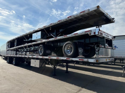 Flatbed trailer with deployed upper deck showing storage underframe and wheels, Utility 4000Ae model features, side rails and rear lighting visible.