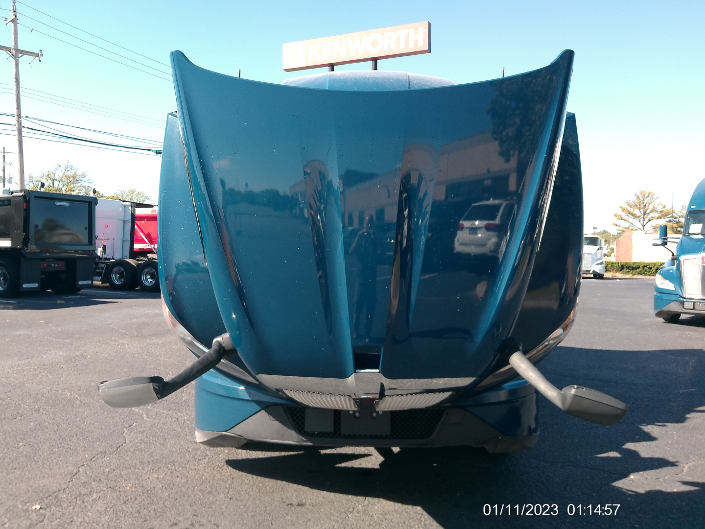 Kenworth T680 truck hood from front view with raised hood scoops and side mirrors visible.