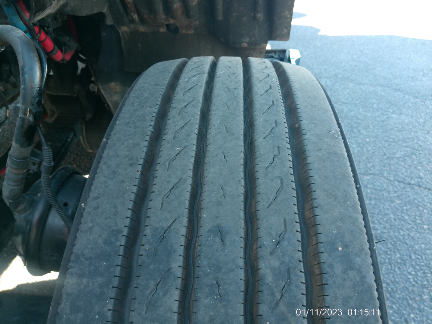 Kenworth T680 wheel/tire and undercarriage view with tread wear visible on front tire.