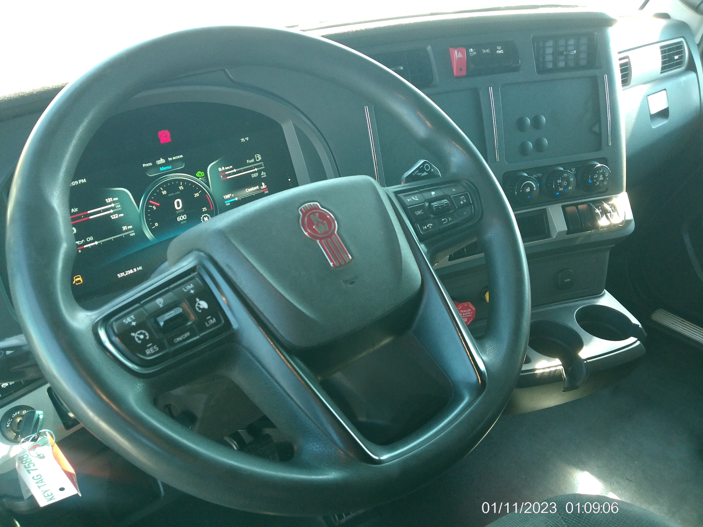 Kenworth T680 interior showing steering wheel and dashboard with controls.