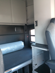 Kenworth T680 interior sleeper cab area with window, storage shelf, and part of driver seat visible.