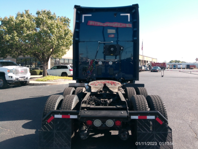 Kenworth T680 rear view showing fifth wheel, rear bumper lights, and dual rear axles in a parking lot.