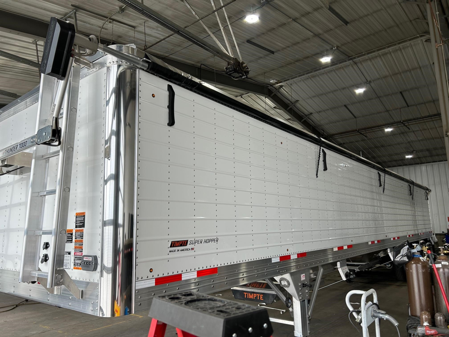 Timpte Super Hopper trailer side view showing aluminum silo with side panels and rain guards.