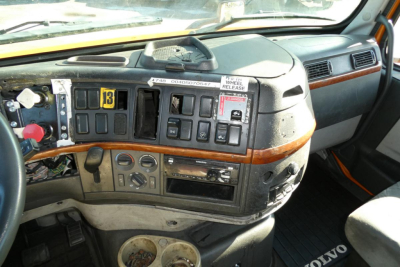 Volvo truck cab dashboard and steering area with control switches and wood trim
