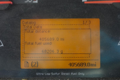 Dashboard display showing total distance 405,689.0 mi and total fuel used 68,206.3 gal with orange LCD display, labels Datalog Total Data Total distance Total fuel used.