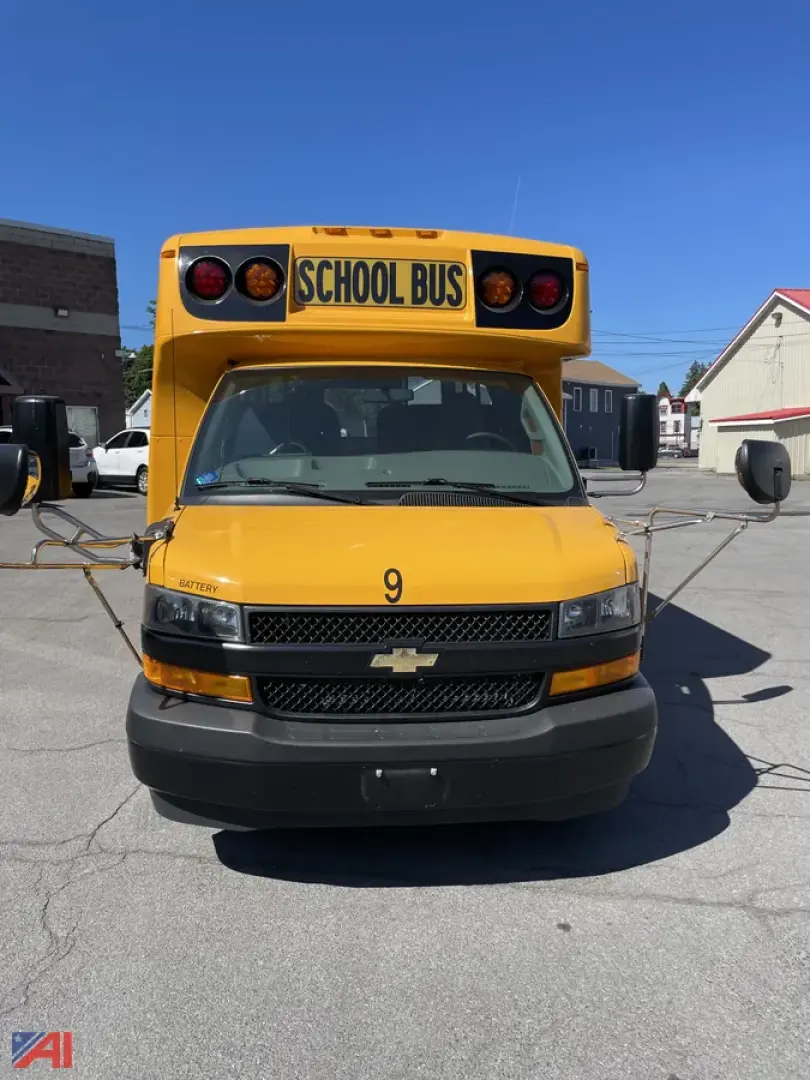 Front view of a yellow 2020 Chevrolet Express G3500 mini school bus with 'SCHOOL BUS' sign on top, black grille, and large side mirrors.