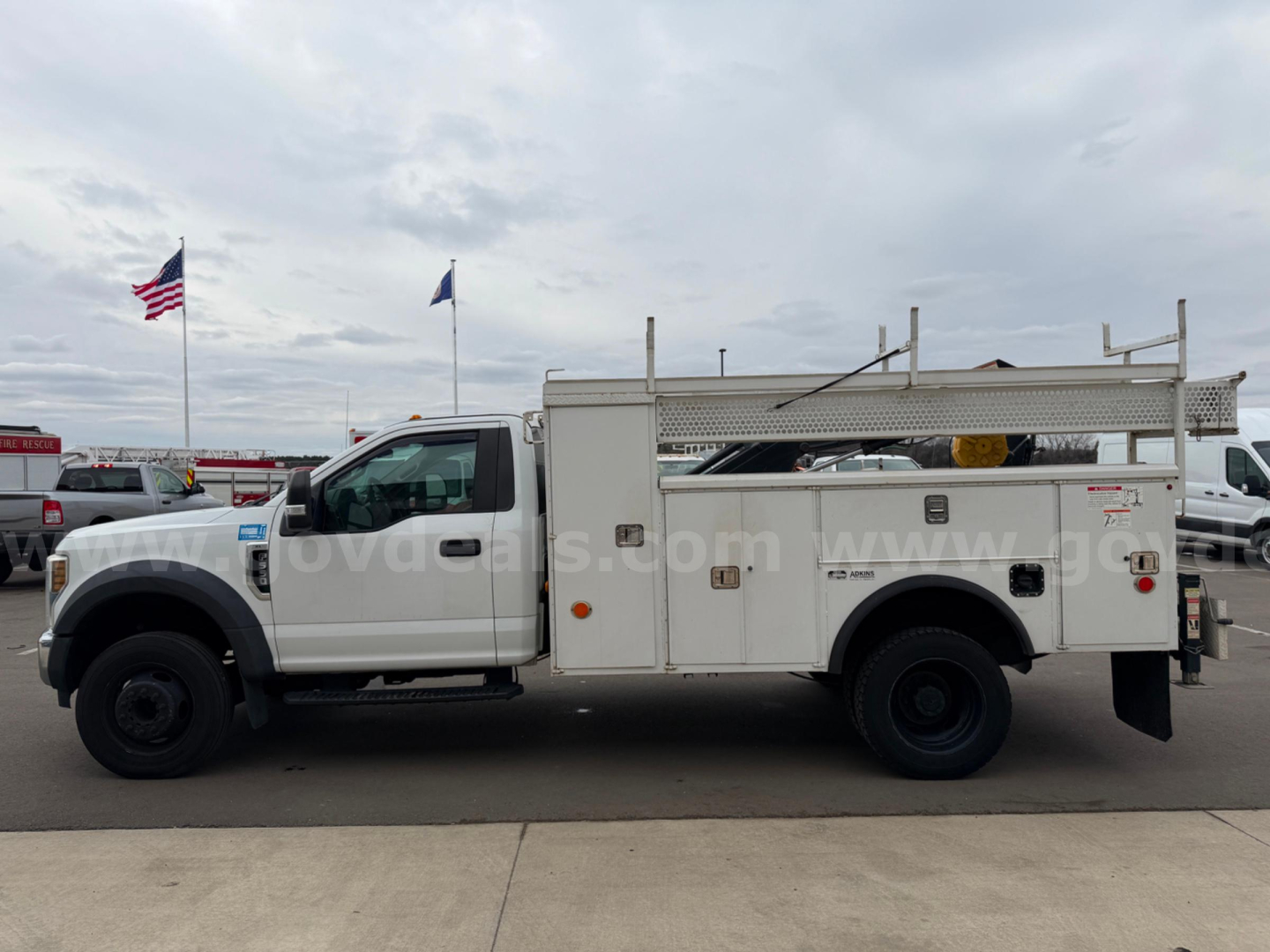 Ford F-550 service/utility truck side view showing utility bed with compartments and ladder rack