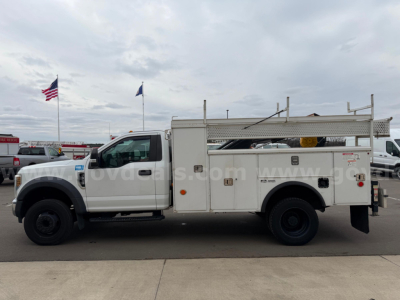 Ford F-550 service/utility truck side view showing utility bed with compartments and ladder rack
