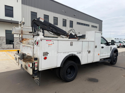 Service/Utility truck shown in profile with utility boxes, crane arm, and storage compartments on white Ford F-550.
