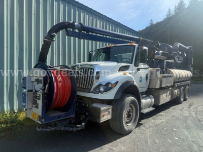 International WorkStar 7500 vacuum truck with front reel and long vacuum hose, white cab, equipment on bed, VIN 1HTWNAZT3DJ296200.