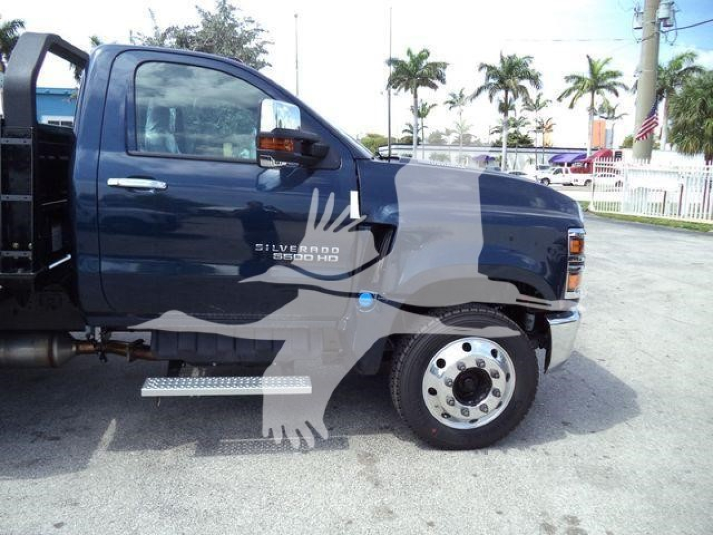 Truck side view of a dark blue 2023 Chevrolet Silverado 6500HD cab with front fender detailing and chrome step, showing ‘Silverado 6500 HD’ badge on door.