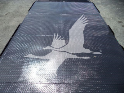 Flatbed showing raised chevy/angel emblem graphic on diamond plate surface.