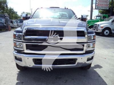 Chevrolet Silverado 6500HD front view showing chrome grille, bumper, and headlights with dealership lot in background.