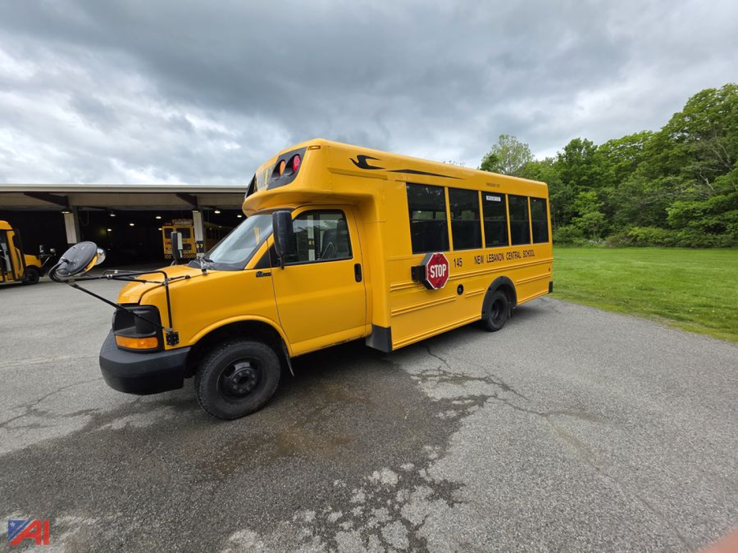 Bus side view showing 2014 Chevrolet Express G4500 mini school bus in yellow with stop sign and school markings