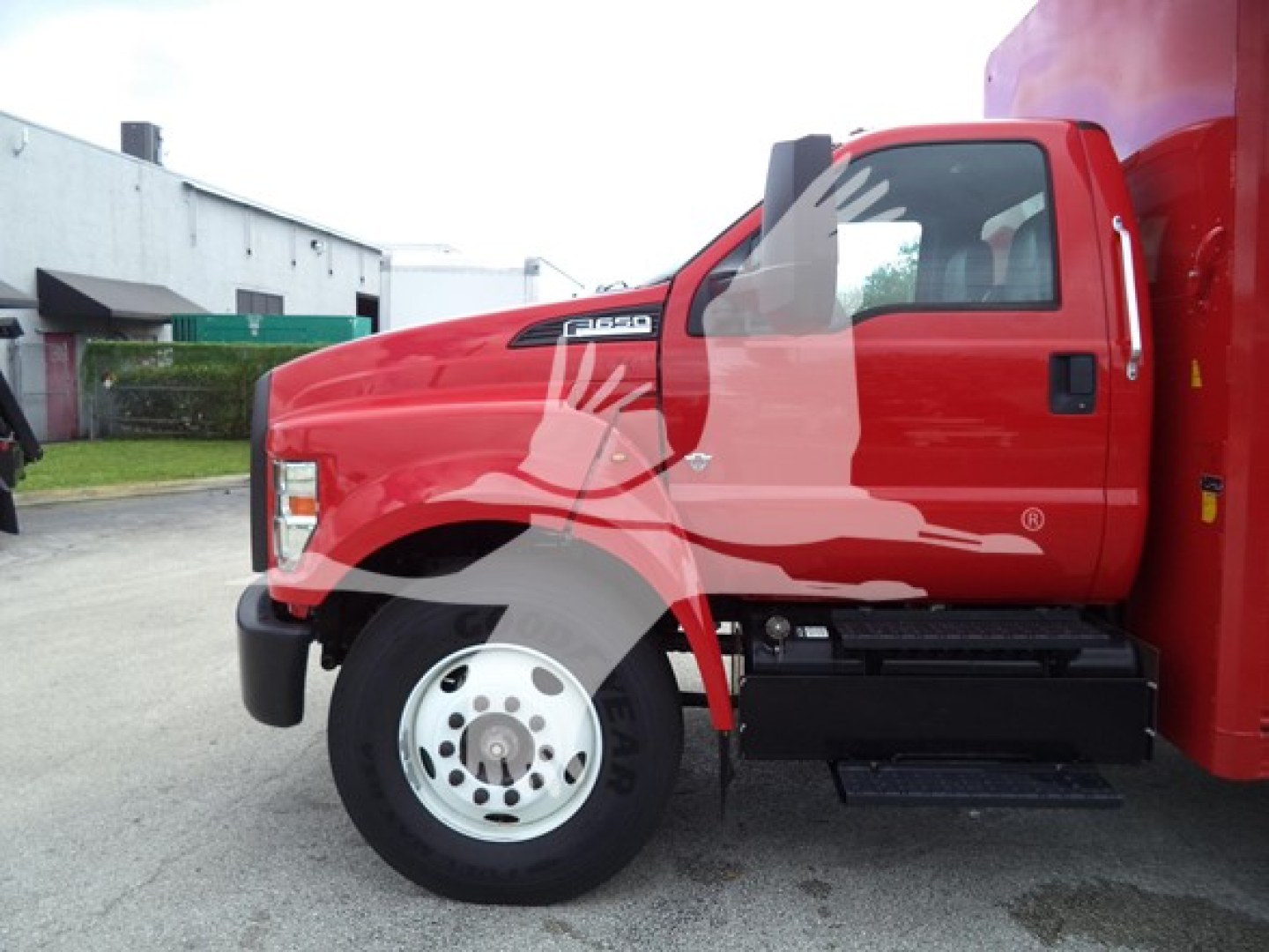 Ford F650 truck side view showing red cab and front wheel, Bev beverage category truck.