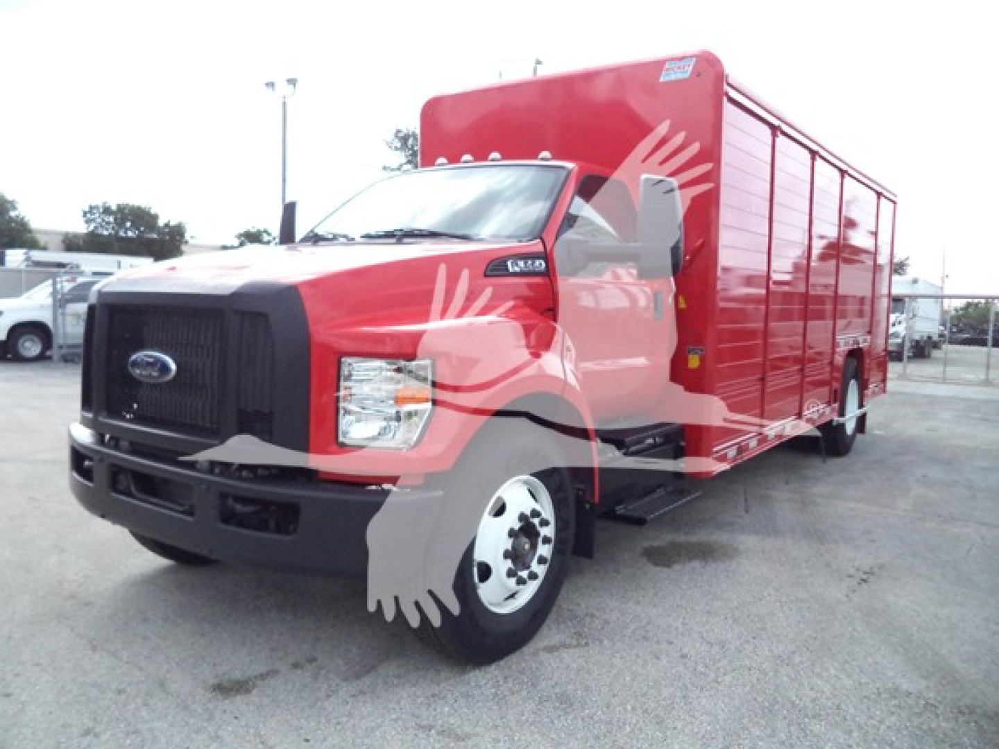 Ford F-650 medium-duty truck in red with cargo box, front view showing grille and headlight, side panels and wheels.