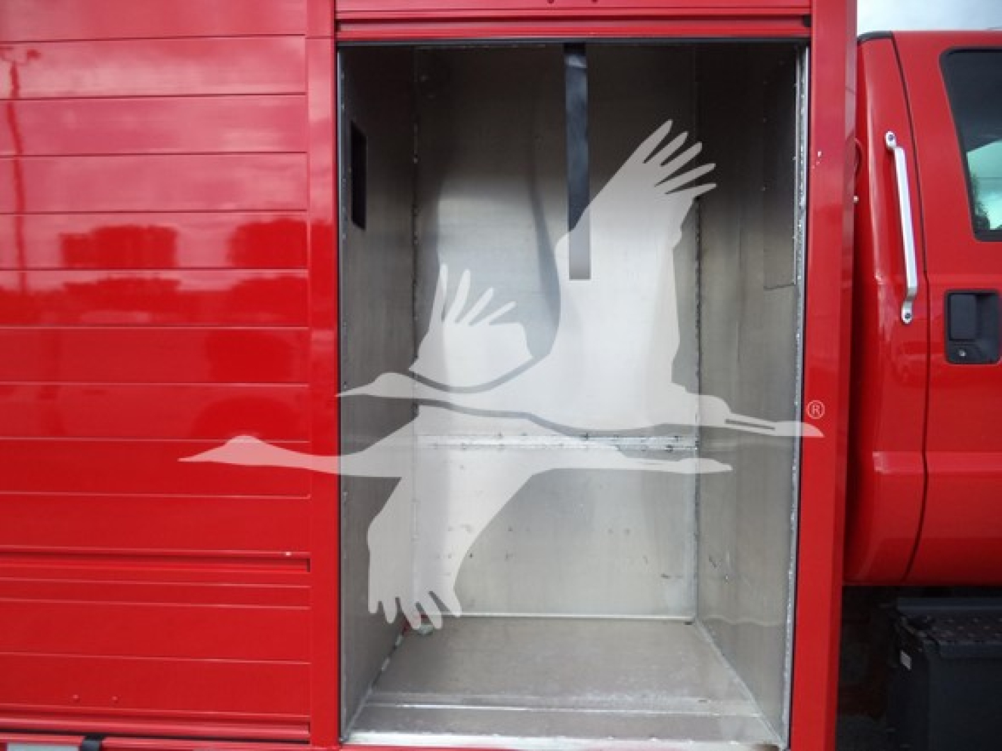 Truck cargo area with open rear doorway showing metallic interior and red exterior.