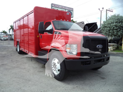 Ford F-650 medium-duty box truck in red, front-left view, with black grille and large side mirrors; cargo box behind cab.
