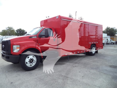 Ford F-650 service truck with red cargo box, side view showing large enclosed rear compartment and cab; clear front grille and wheel; no visible text on body.