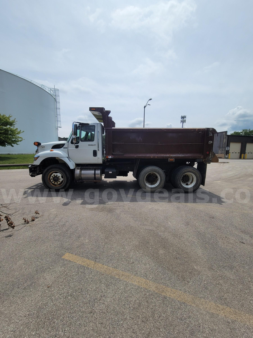 Dump truck side view of a 2008 International 7400 with a brown dump bed and white front cab.