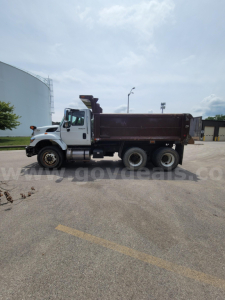 Dump truck side view of a 2008 International 7400 with a brown dump bed and white front cab.