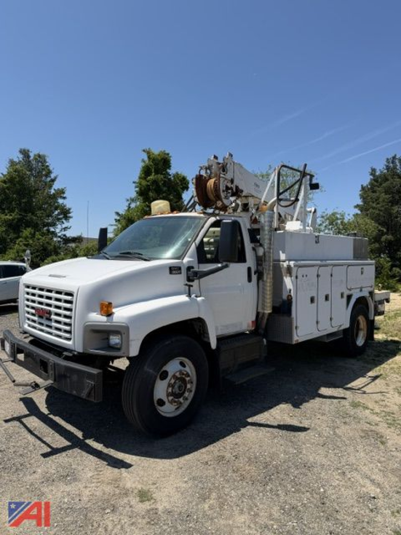 GMC C8500 digger truck in-service showing crane equipment mounted on service body with compartments and white cab.