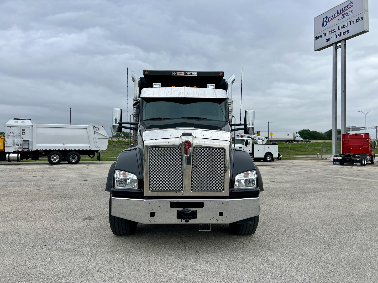 Kenworth T880 dump truck front view showing chrome grille, bumper, and headlights.