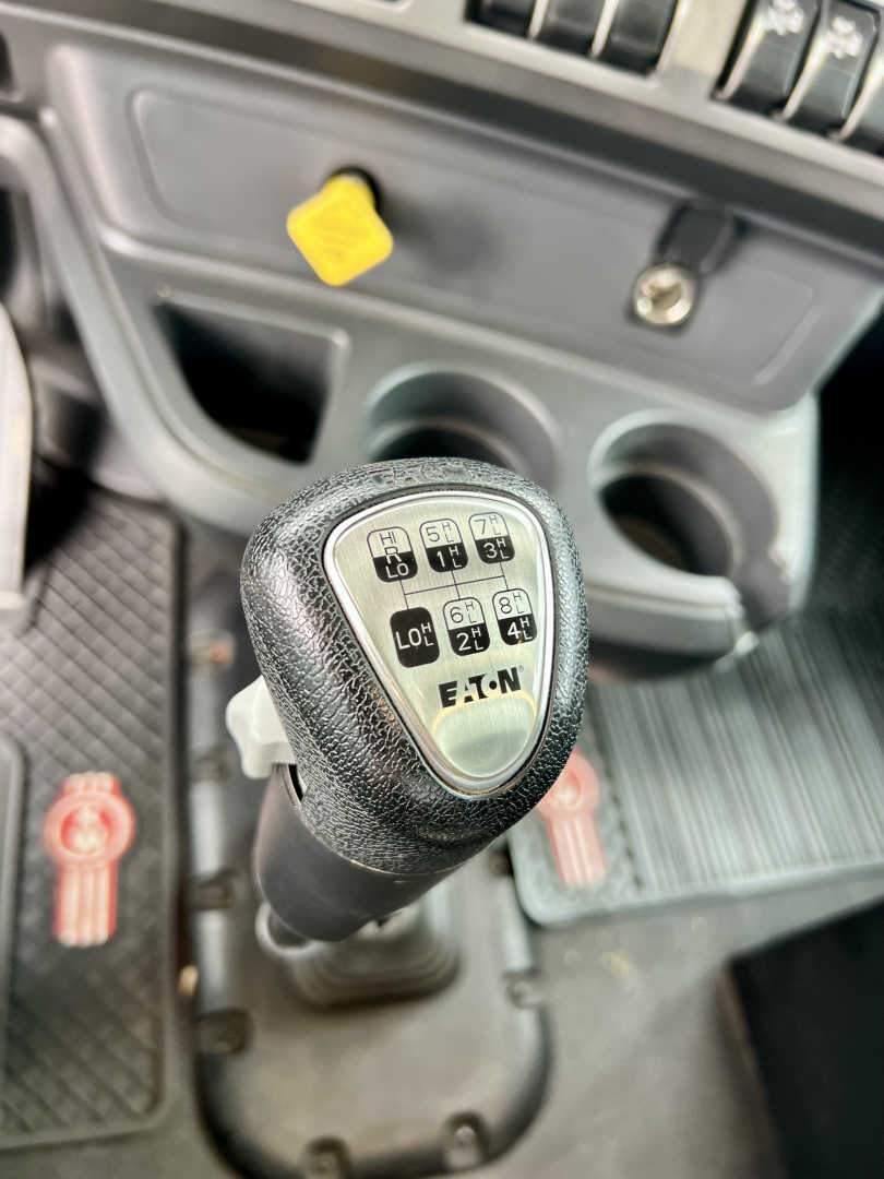 Kenworth T880 dump cab interior showing shift lever with EATON transmission shift pattern and surrounding controls.