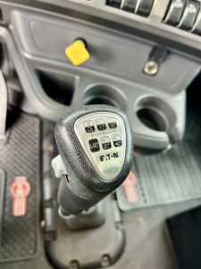 Kenworth T880 dump cab interior showing shift lever with EATON transmission shift pattern and surrounding controls.
