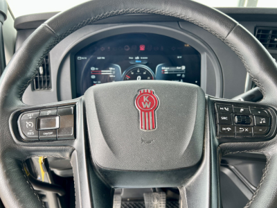 Kenworth T880 steering wheel with KW emblem and dashboard visible in the background.