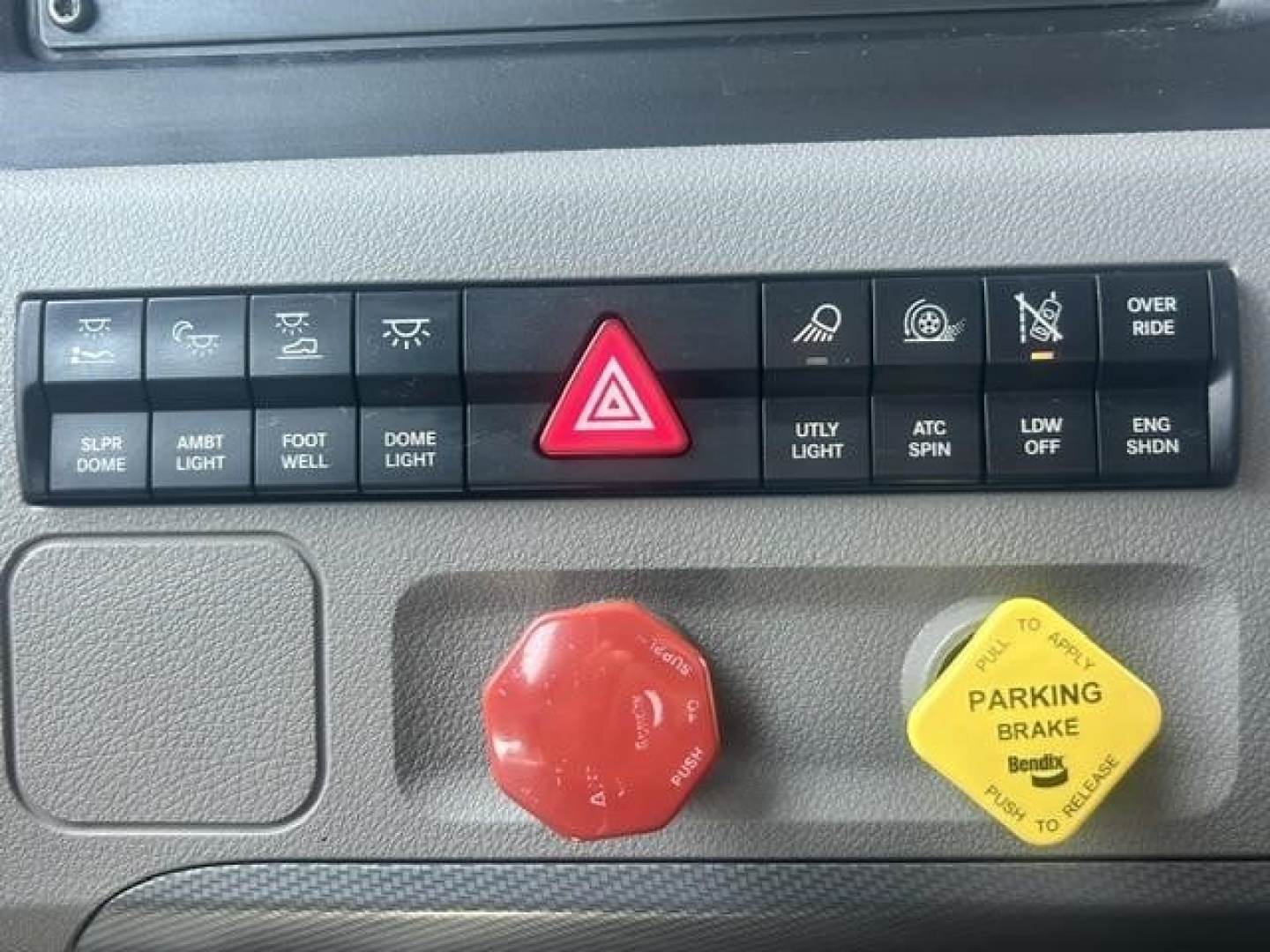 Dashboard of a 2022 Freightliner Cascadia 126 showing control panel with hazard button, utility light, and parking brake yellow knob.